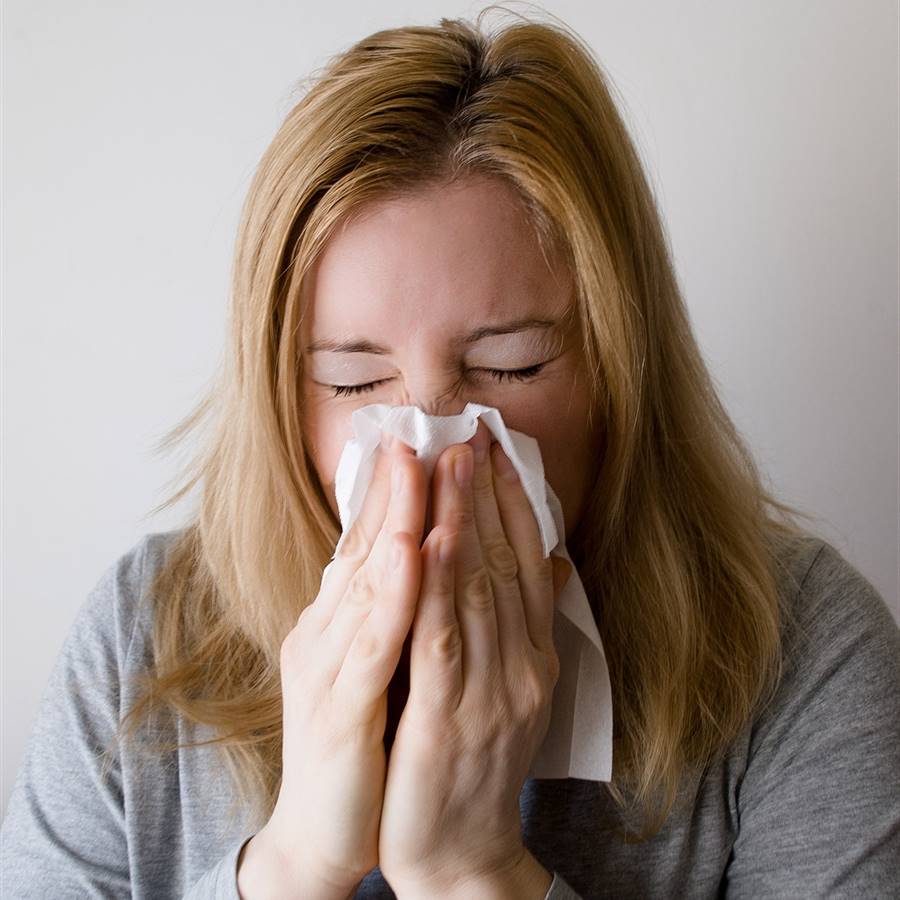 Mujer con un pañuelo estornudando