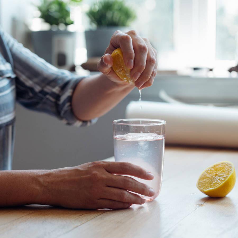 Mujer echando zumo de limón al agua