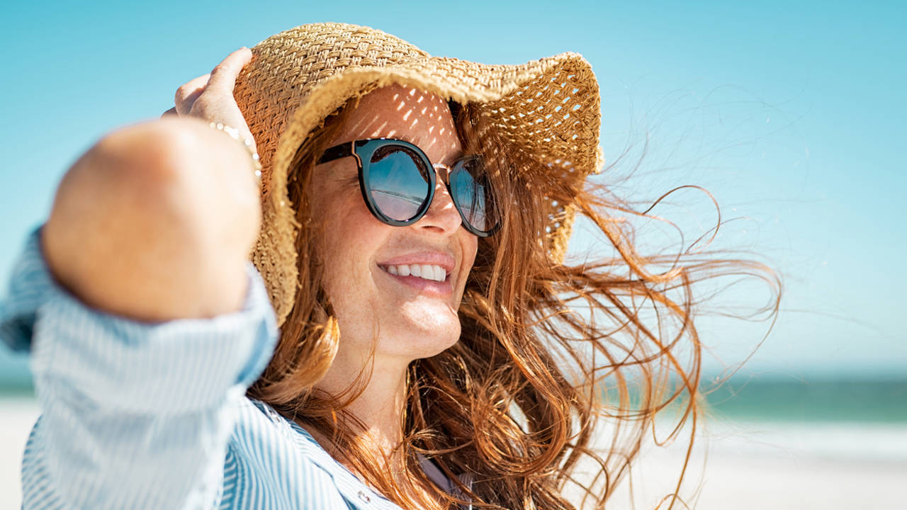 Mujer con gafas de sol en la playa