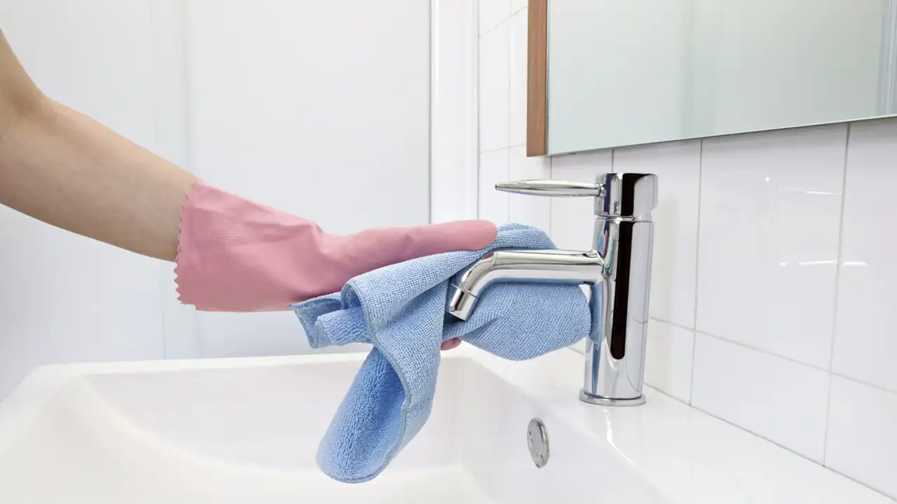 Mujer limpiando un grifo del baño