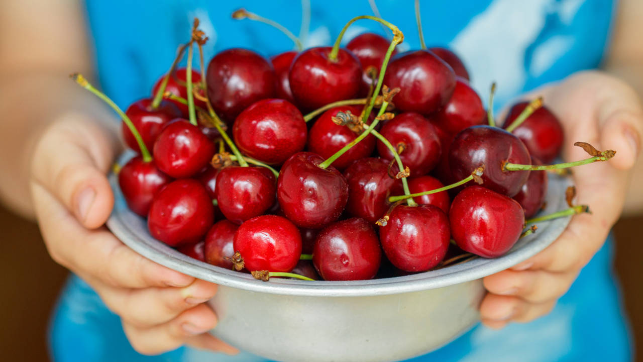 Mujer con un cuenco de cerezas