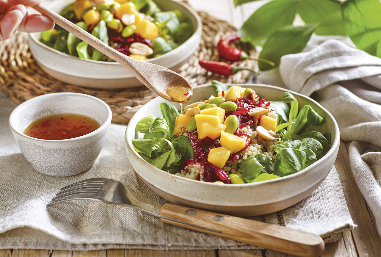 Quinoa, edamames y mango sobre un lecho verde de canónigos