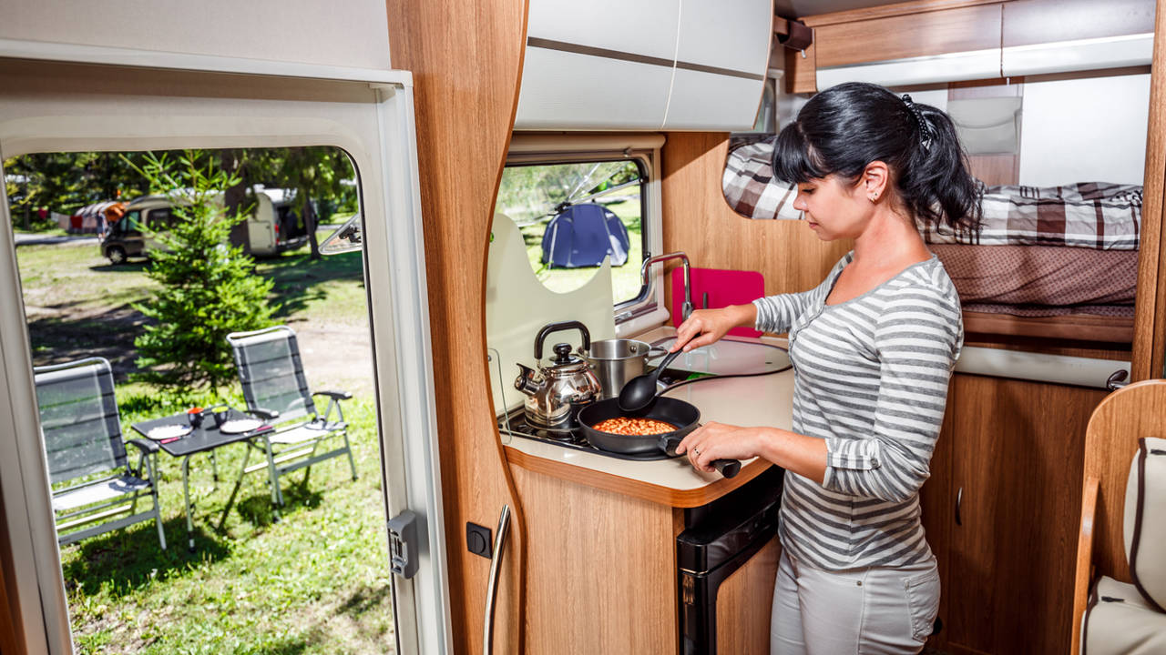 Mujer cocinando en una autocaravana