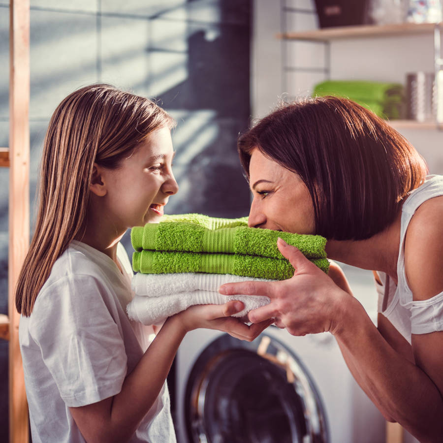 Madre e hija oliendo unas toallas limpias