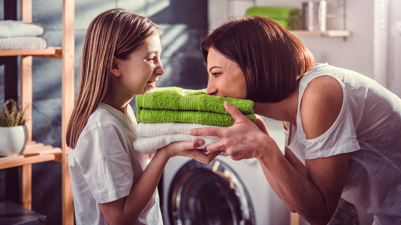 Madre e hija oliendo unas toallas limpias