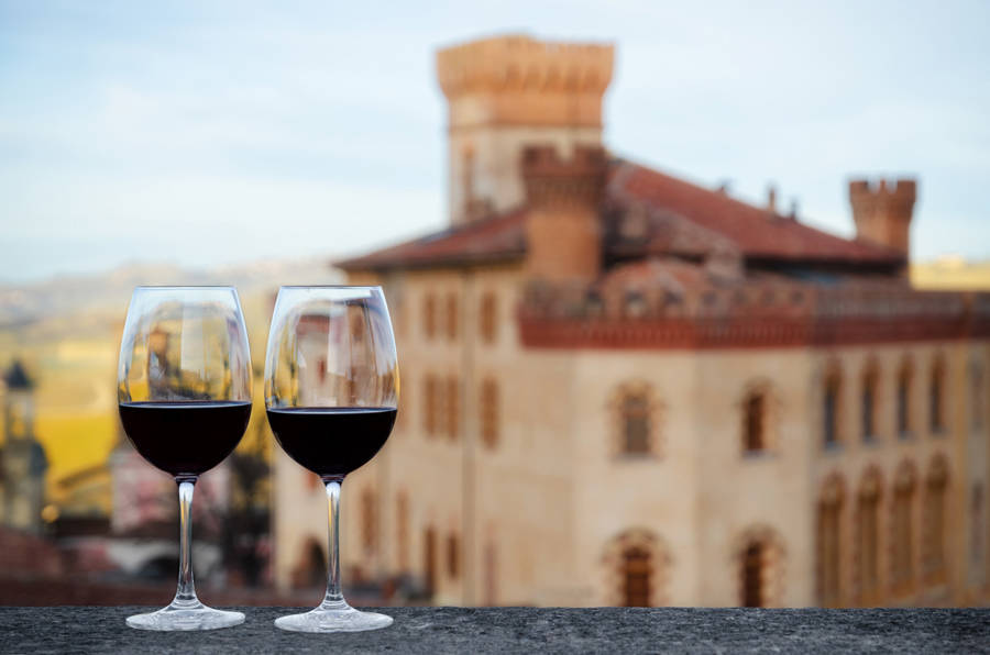 Dos copas de vino con el castillo de Barolo al fondo