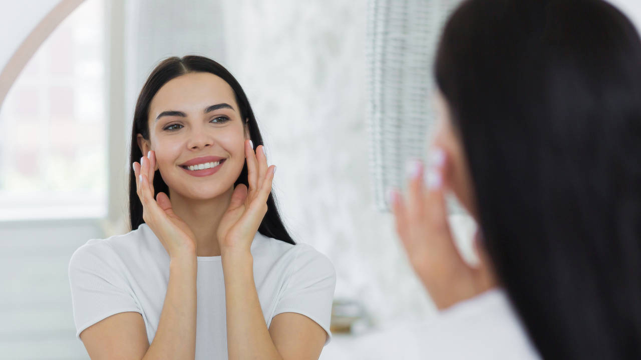 Mujer contemplando su rostro en un espejo