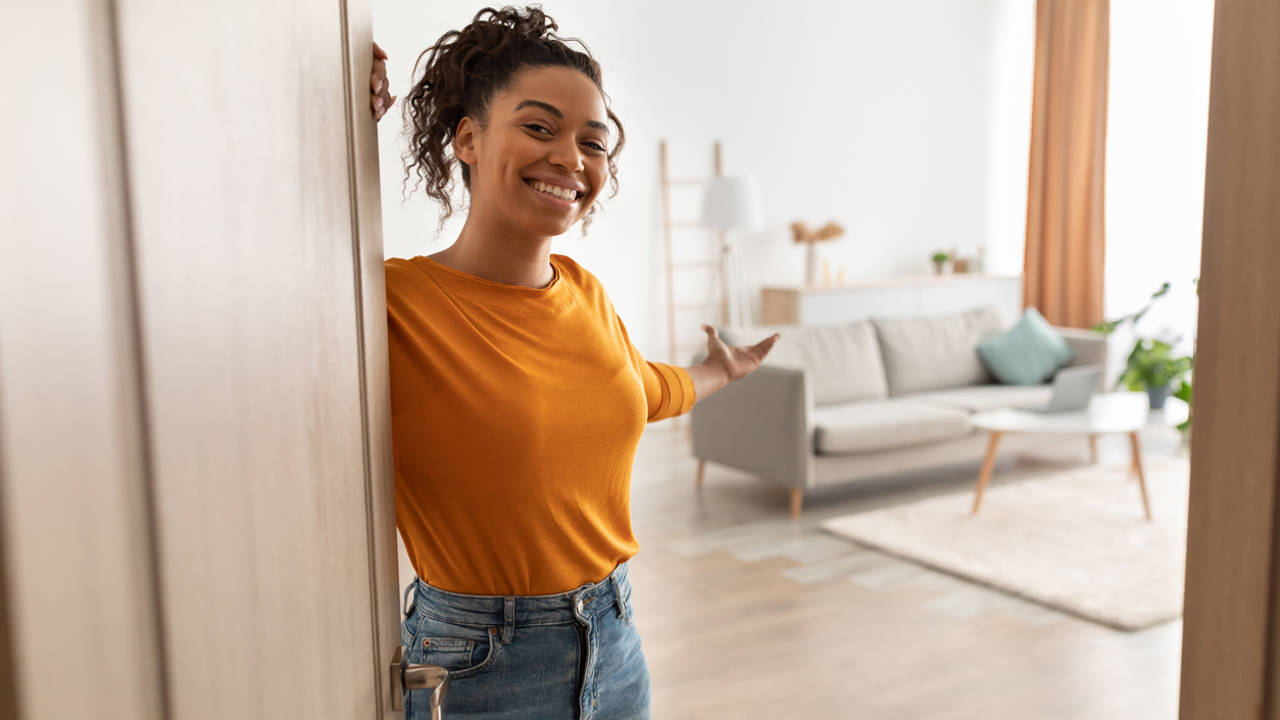 Mujer abriendo la puerta de su hogar