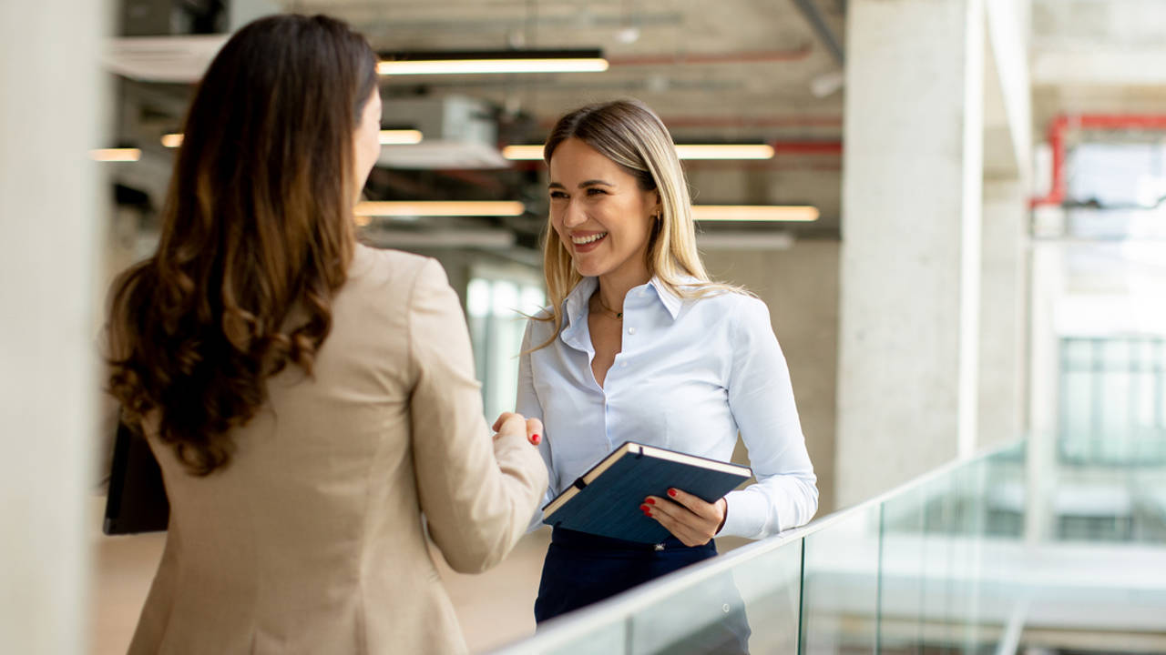 dos mujeres hablando en la oficina