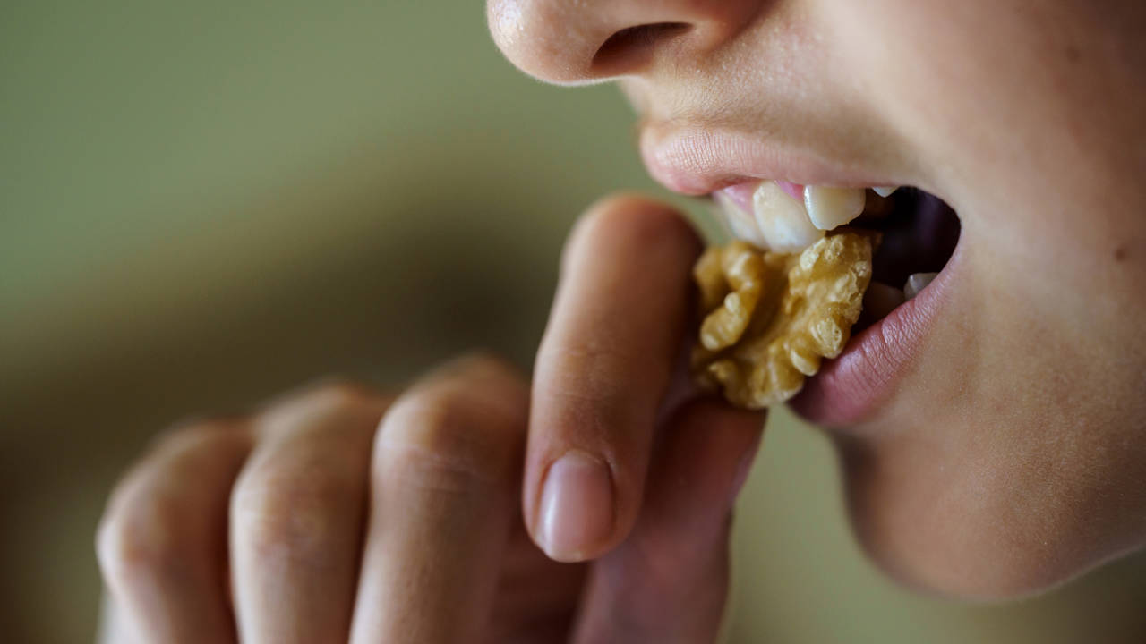 Mujer comiendo una nuez