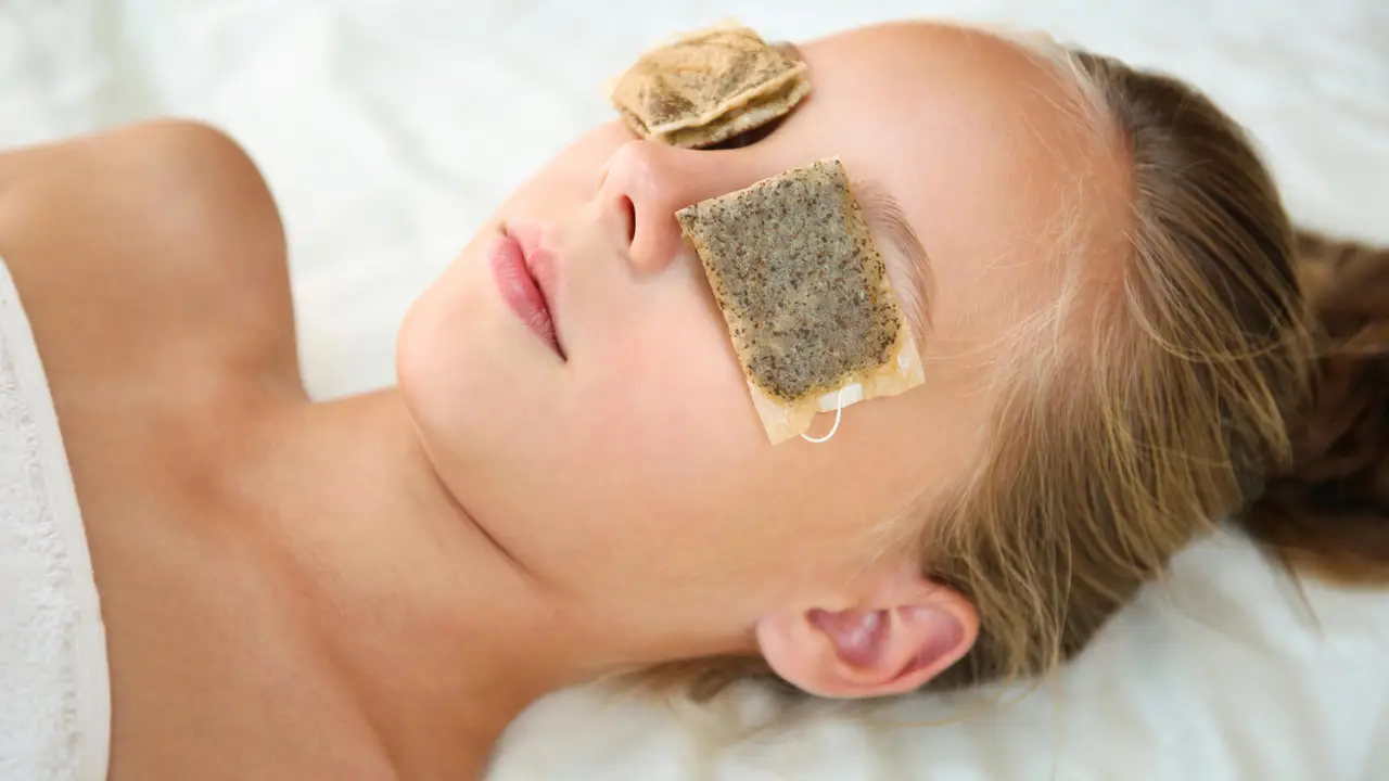 Mujer con bolsitas de infusión en los ojos