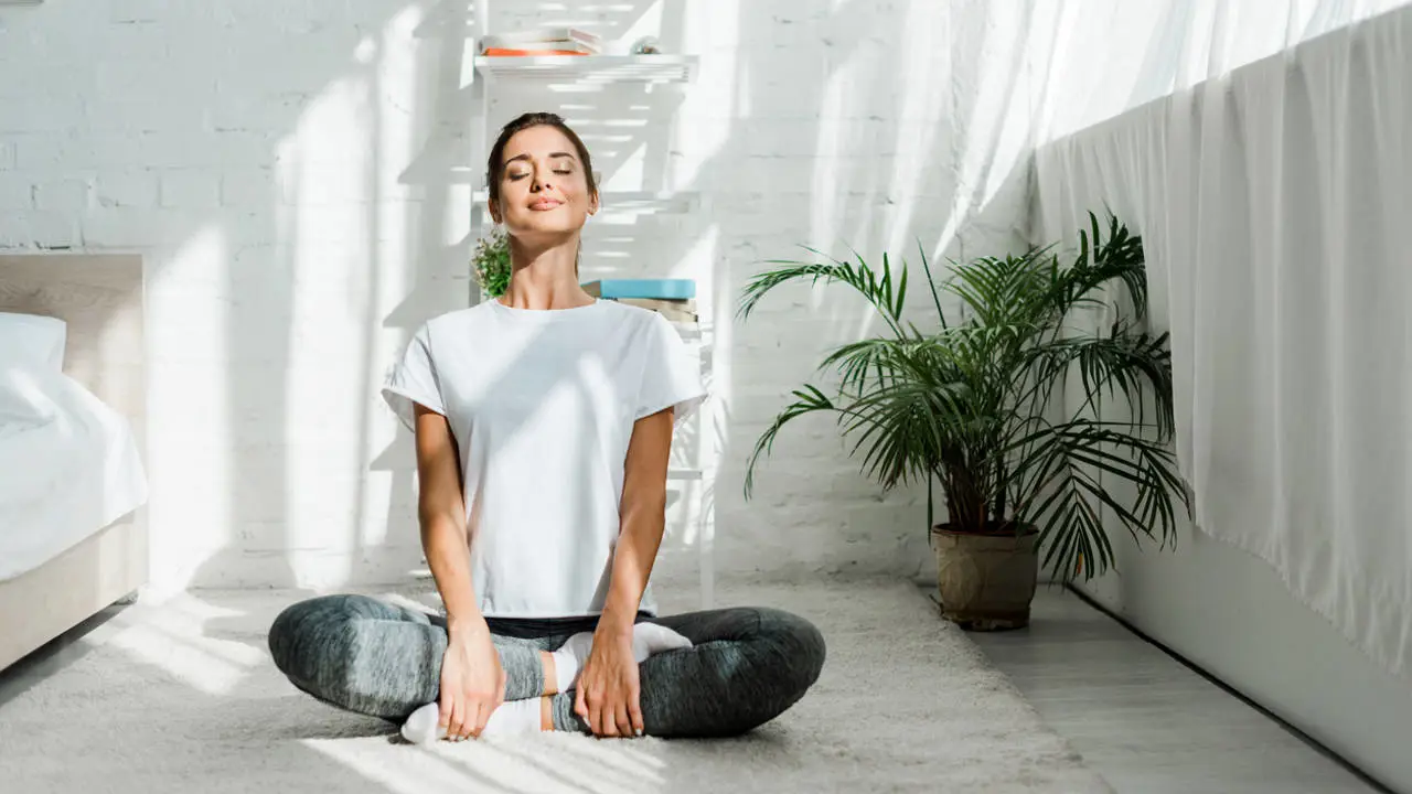 Mujer haciendo yoga por la mañana