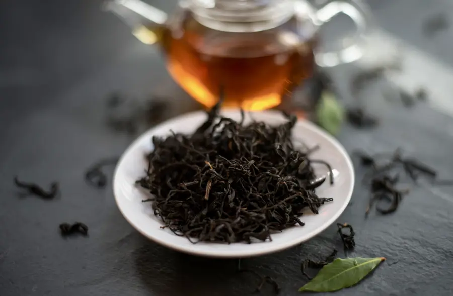 Té negro con tetera al fondo