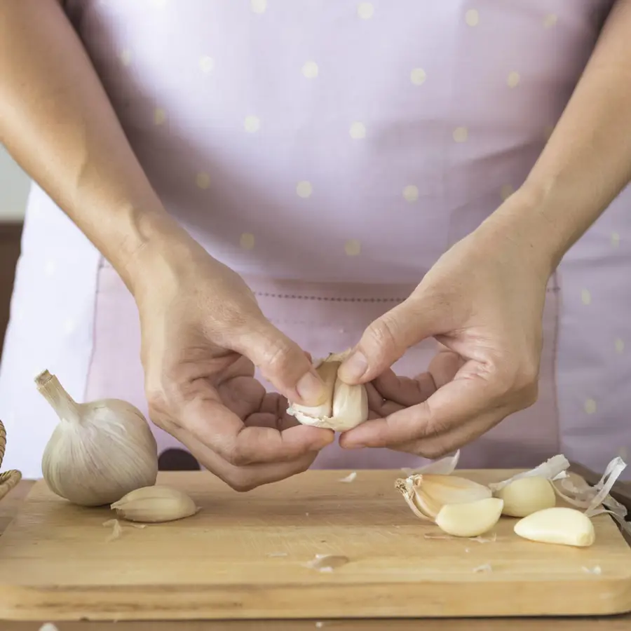 Mujer pelando ajos