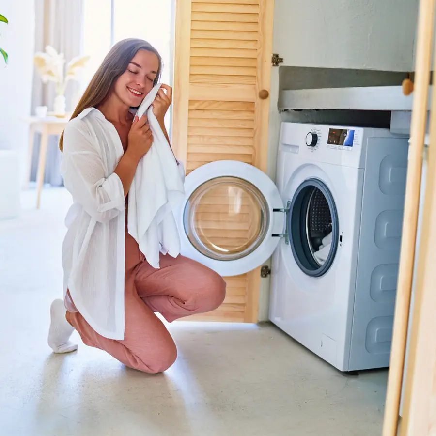 Mujer sacando la ropa de la lavadora