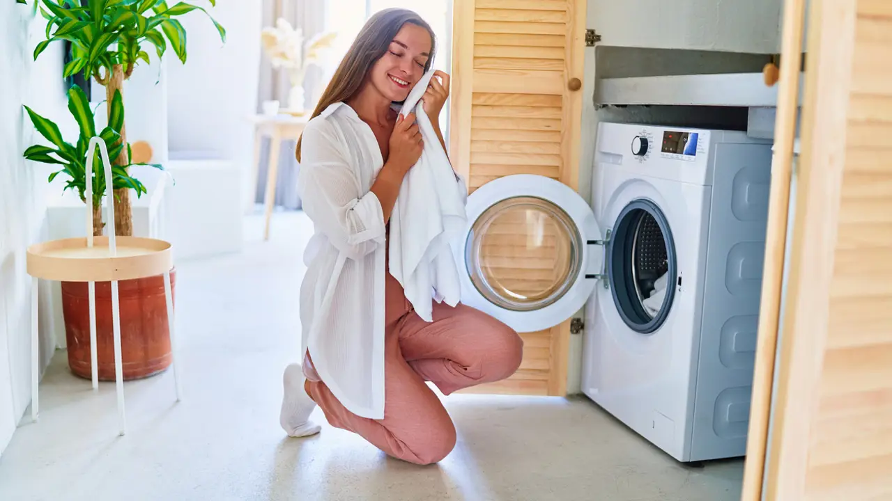 Mujer sacando la ropa de la lavadora