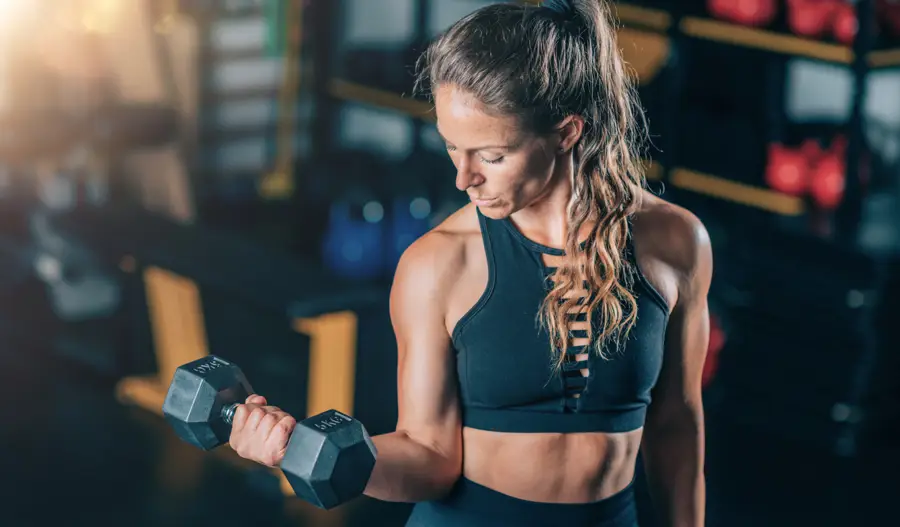 Mujer gimnasio de pie pesas