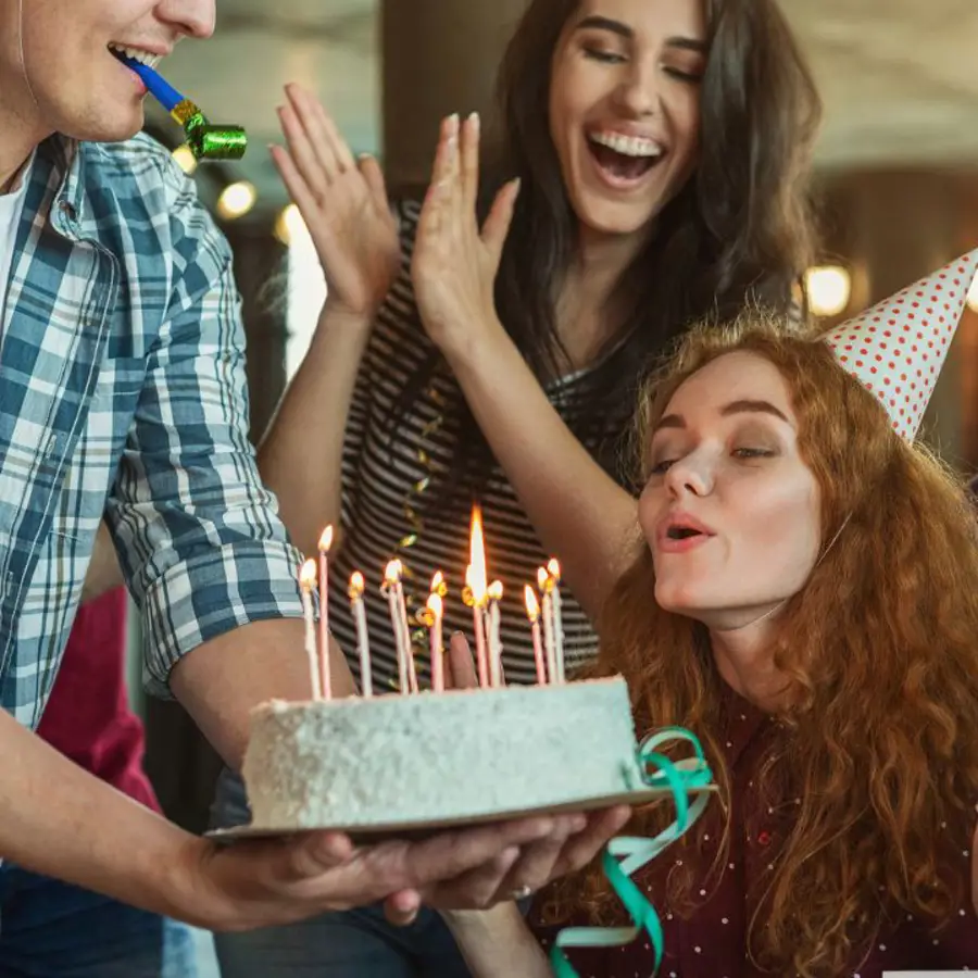 Mujer soplando velas de cumpleaños