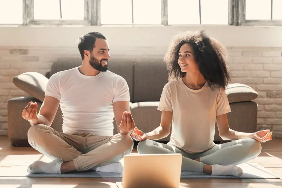 Pareja a punto de meditar, con complicidad