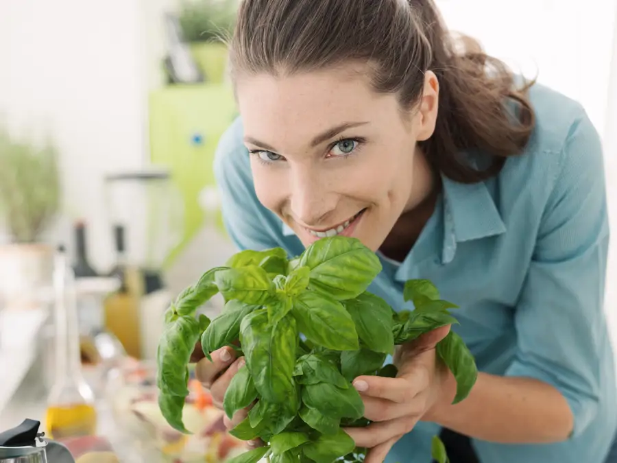 mujer sosteniendo albahaca