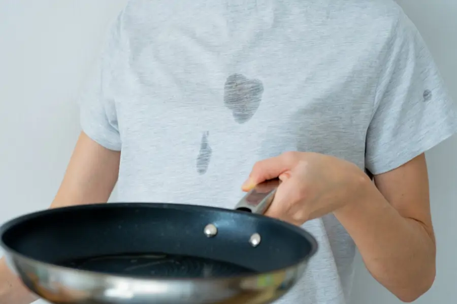 Mujer con manchas de grasa en la camiseta