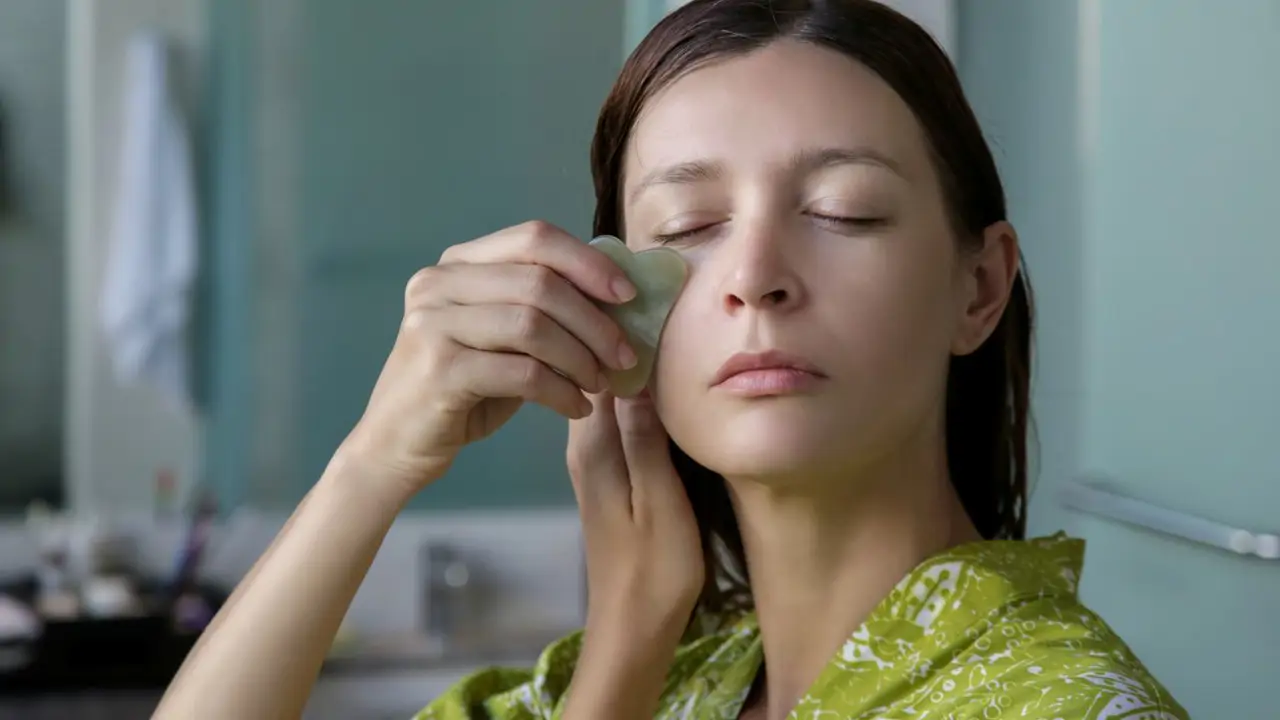 Mujer masajeándose con una piedra gua-sha