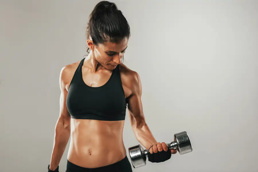 Mujer muy musculada haciendo pesas