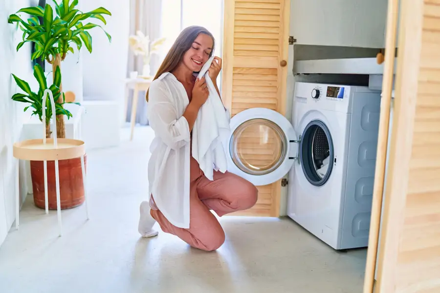 Mujer sacando la ropa de la lavadora