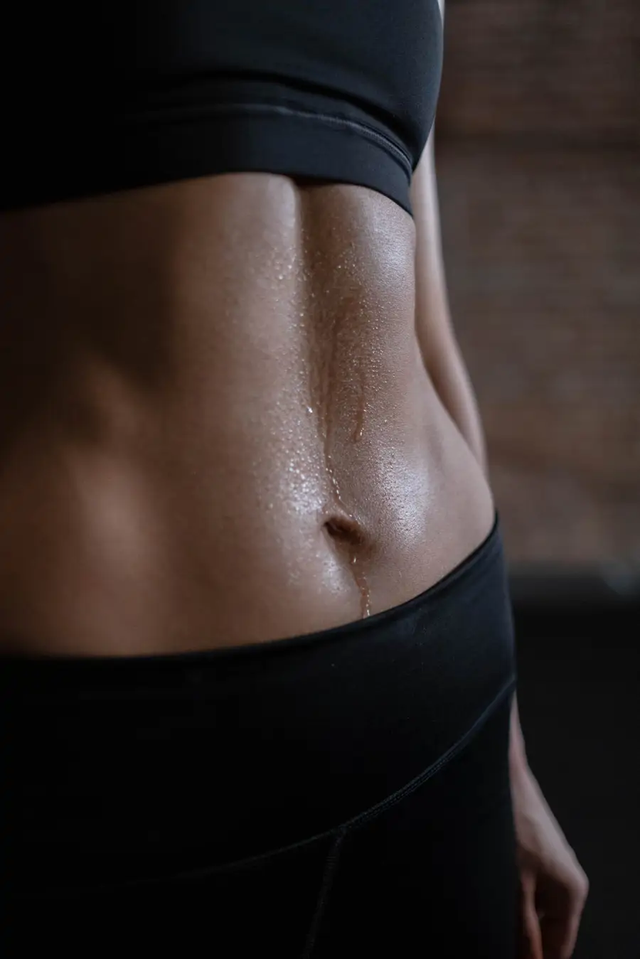 Barriga de chica deportista con sudor