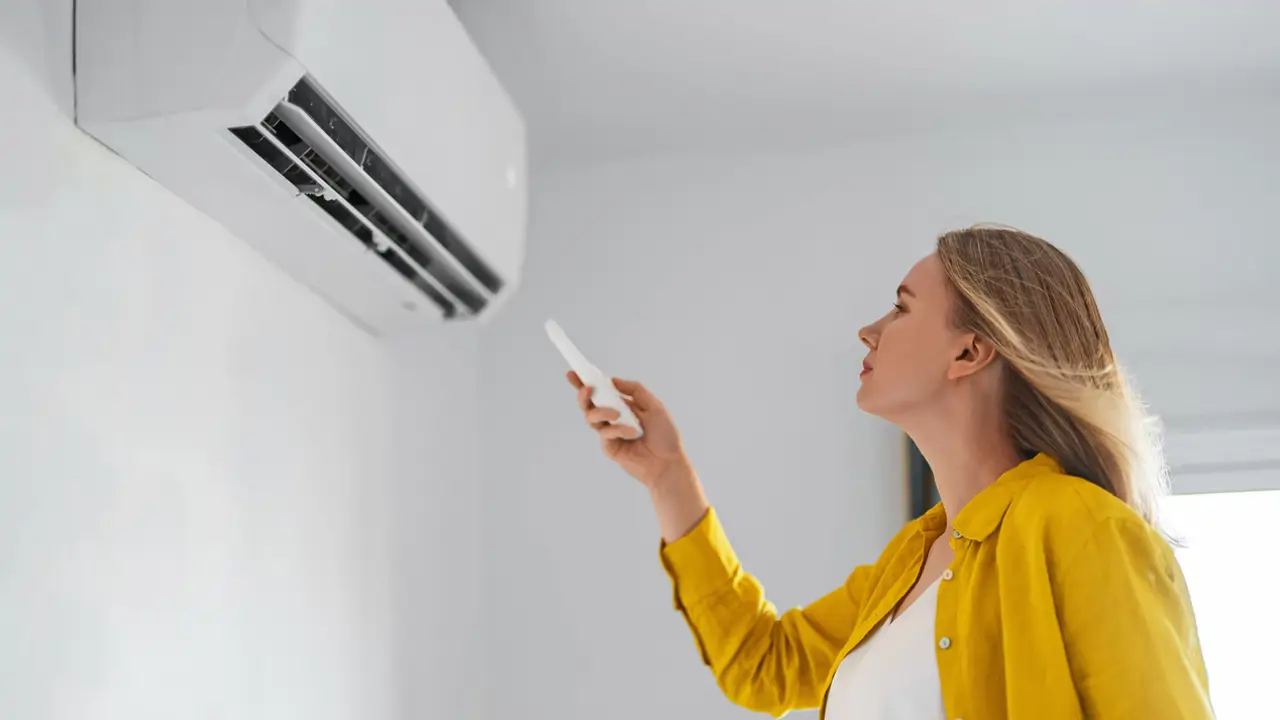 mujer poniendo el aire acondicionado
