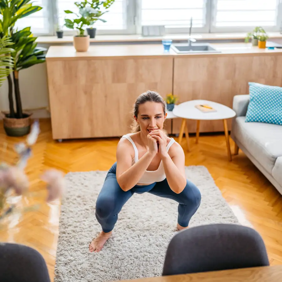 Mujer sentadilla en casa