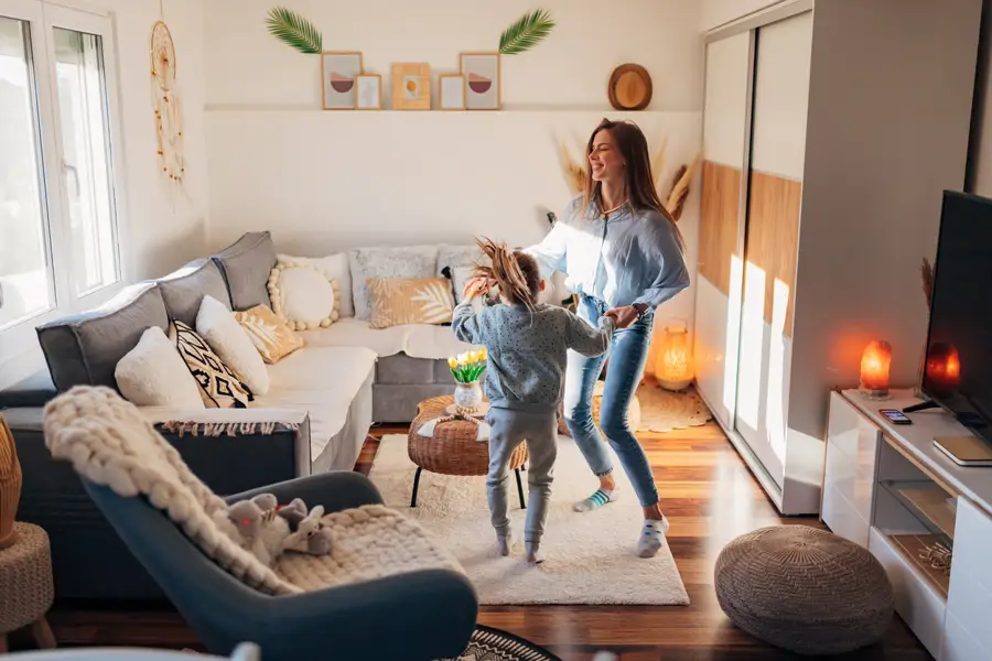 Madre e hija bailando en comedor de casa