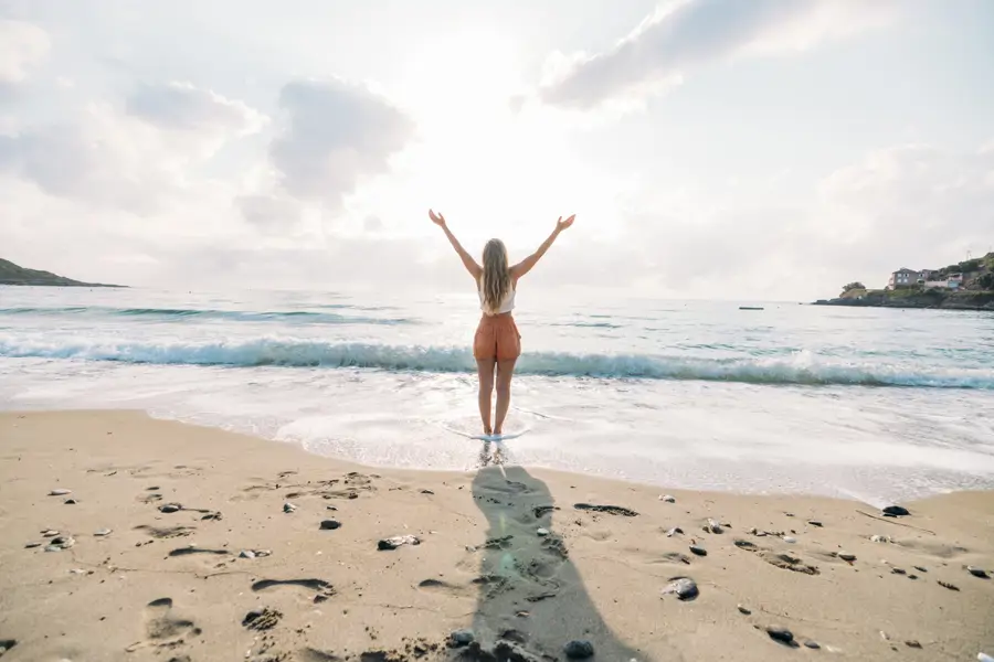 Mujer de espaldas en la playa felicidad plenitud