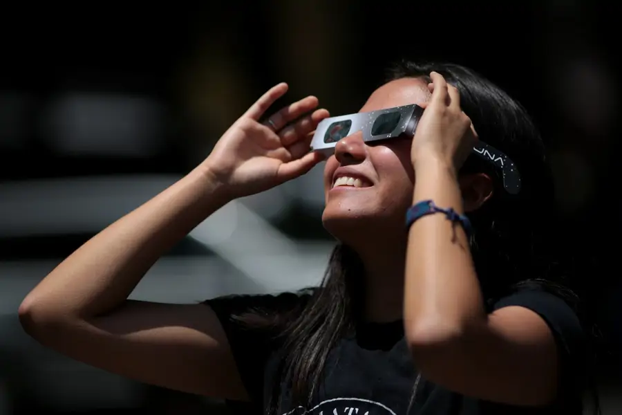 Mujer con gafas especiales para ver eclipse solar